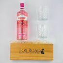 Gordons Pink Gin and Glass Tumblers beside wooden gift crate