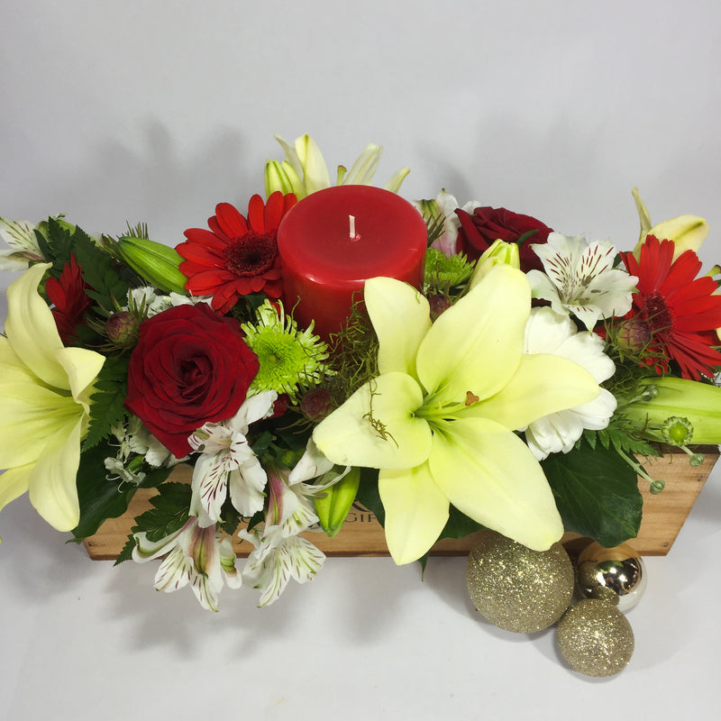 Lilies, roses and Christmas baubles in a wooden gift box