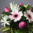 Close up of Gerberas, roses and fresh greenery in a vase