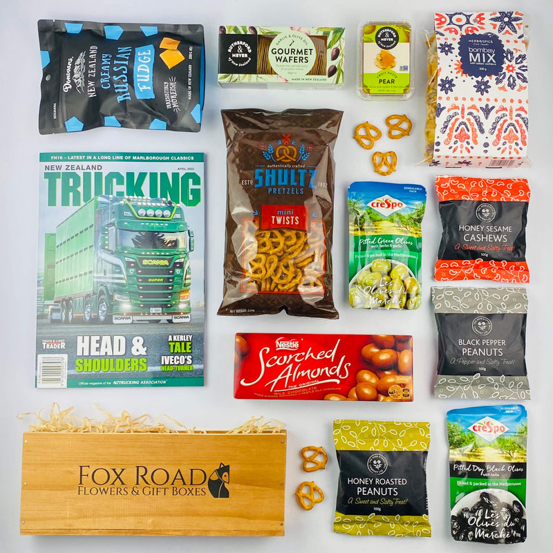 NZ Trucking Magazine with snacks by wooden gift box.